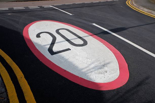 istock Twenty mile an hour speed limit sign painted on tarmac road surface 1385090587