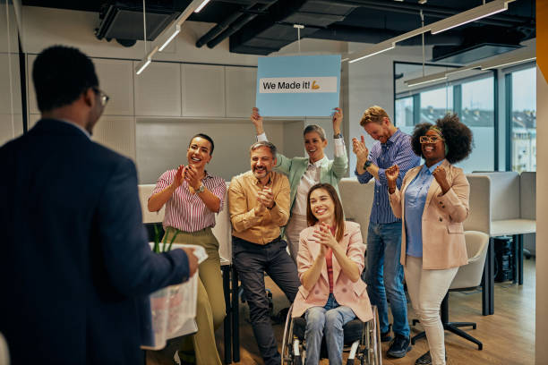istock Coworkers greets their male colleague who return to work 1385091008
