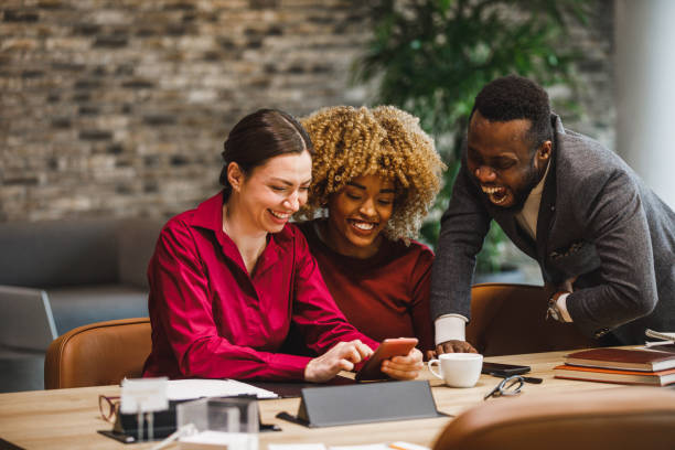 istock Three diverse business colleagues looking at funny memes and laughing 1385092260