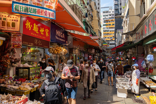 Hong Kong - March 14, 2022 : People at the wet market in Wan Chai, Hong Kong. The street is full of vendors selling fresh food, vegetable and seafood.