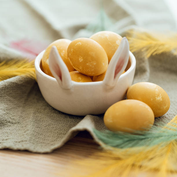 Colorful eggs in a egg carton on a white background with space for copy