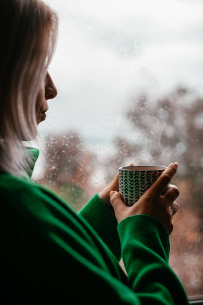 istock Depressed Woman Watching the Rain Through the Window 1385093331