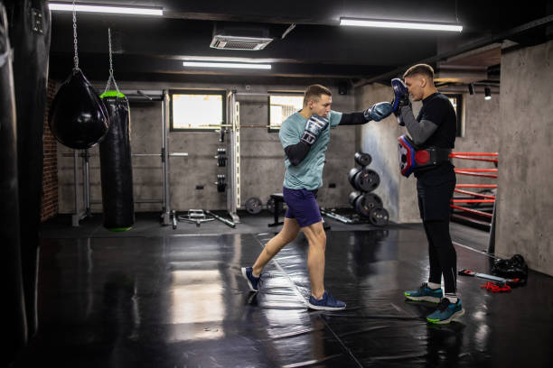 istock Male boxer Caucasian ethnicity, having a kickboxing training with his coach 1385093456