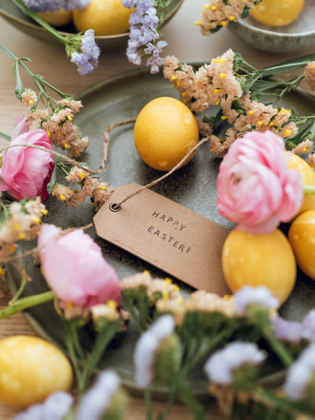 istock Yellow natural colored easter egg and flowers with text happy easter 1385093525