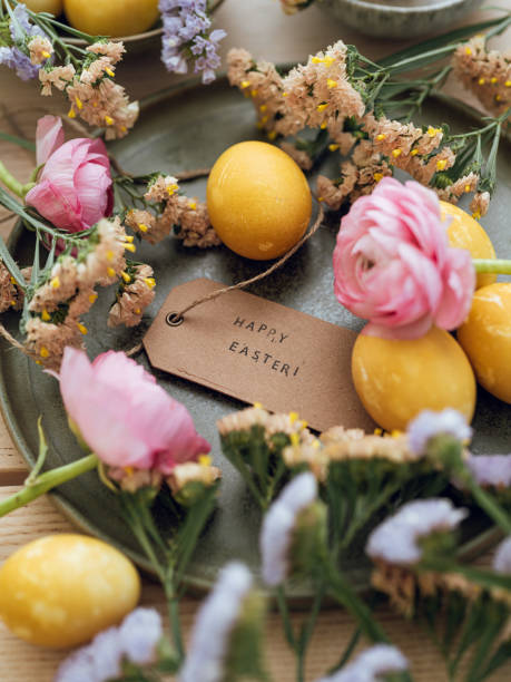 istock Yellow natural colored easter egg and flowers with text happy easter 1385094512