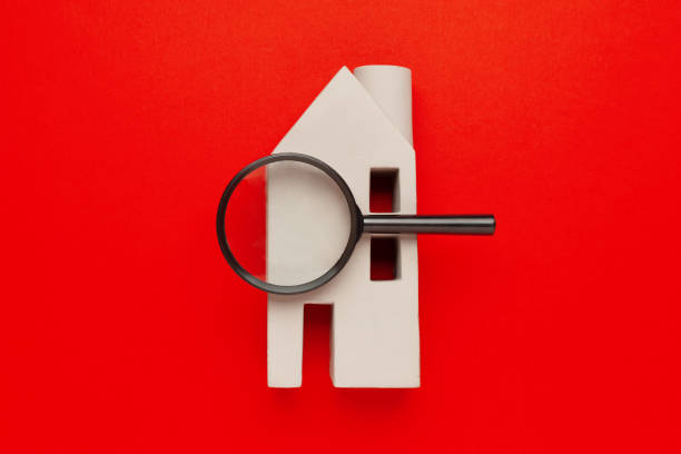 House model and a magnifying glass on a red background. Property search. House model and a magnifying glass on a red background. Property search. neighborhood crime watch stock pictures, royalty-free photos & images