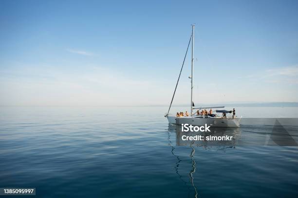 Friends Sitting On Sailboat Stock Photo - Download Image Now - Sailboat, Sailing, Sea