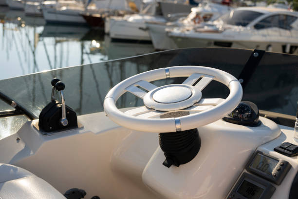 Luxury yacht control panel with steering wheel, gear levers, navigation devices, control buttons and on-board computer.
