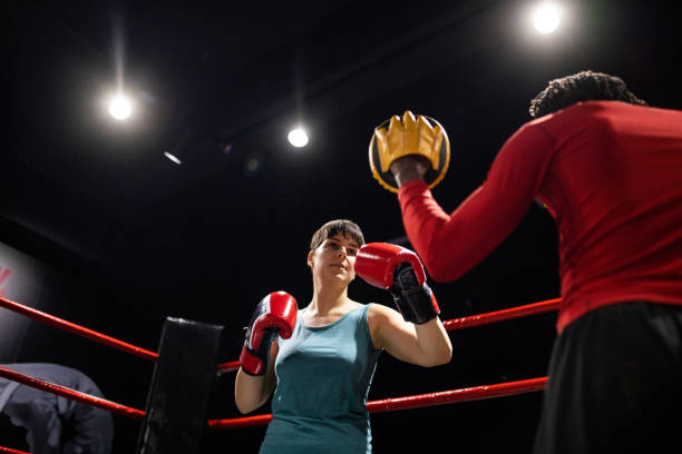 istock Male boxing instructor Black ethnicity having a training with a woman in the boxing ring 1385096621
