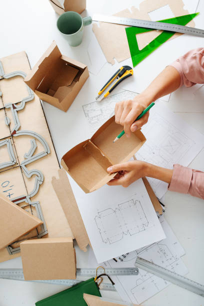 istock Female hands holding a box in hands, making marks with a pencil 1385096920