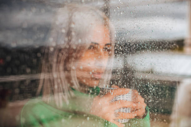 istock Depressed Woman Watching the Rain Through the Window 1385097372