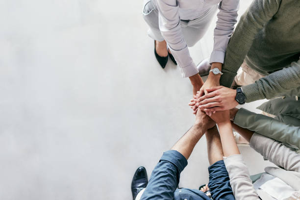 istock Shot of a group of unrecognizable businesspeople stacking their hands at work 1385097499