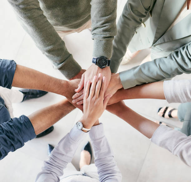 istock Shot of a group of unrecognizable businesspeople stacking their hands at work 1385097505