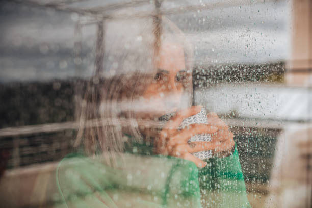 istock Depressed Woman Drinks Coffee by the Window 1385097569