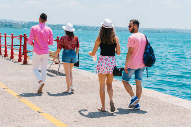 istock Tourists sightseeing a city while walking on a boardwalk on a sunny summer day. 1385099180