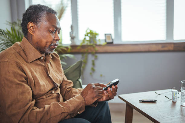 primer plano de las manos de un hombre africano que verifica el nivel de azúcar en la sangre por un medidor de glucosa - diabetes blood illness chronic fotografías e imágenes de stock