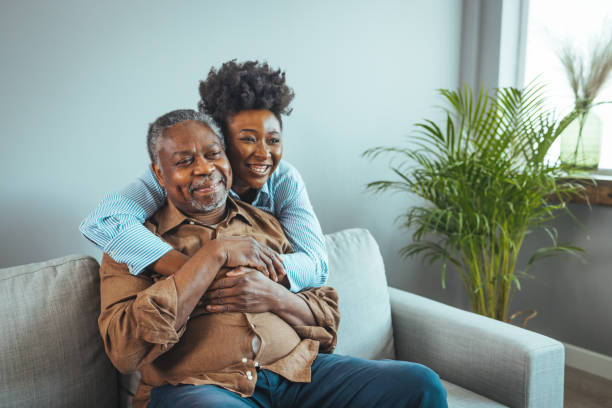 senior man and his middle aged daughter smiling at each other embracing, close up. - mid aged woman imagens e fotografias de stock