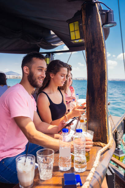 istock Two friends hanging out, talking and drinking coffee on a boat 1385099944