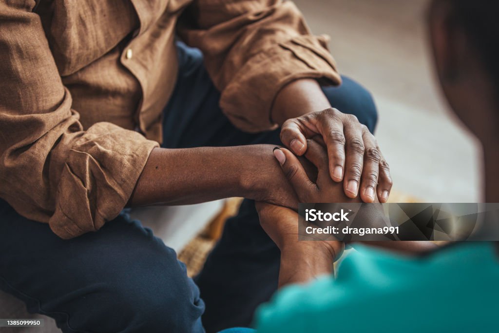 Closeup of a support hands. Closeup of a support hands. Closeup shot of a young woman holding a senior man's hands in comfort. Female carer holding hands of senior man Community Outreach Stock Photo
