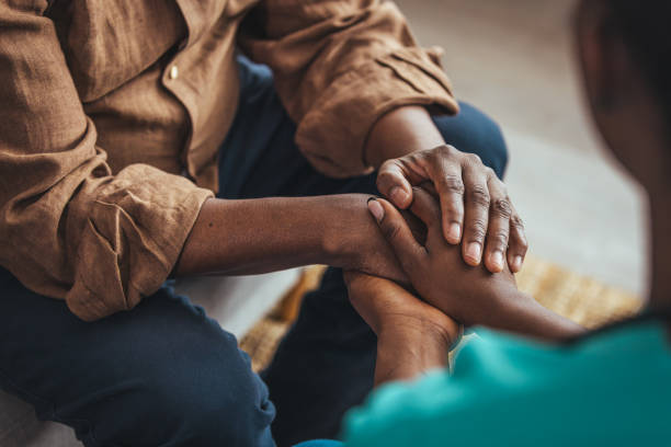 Closeup of a support hands. Closeup of a support hands. Closeup shot of a young woman holding a senior man's hands in comfort. Female carer holding hands of senior man community outreach photos stock pictures, royalty-free photos & images