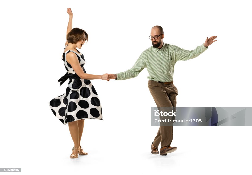 Dynamic portrait of couple of dancers in vintage retro style outfits dancing lindy hop dance isolated on white background. Concept of art, action, motion Happy and beautiful. Dynamic portrait of couple of dancers in vintage retro style outfits dancing lindy hop dance isolated on white background. Concept of art, action, motion. Old-fashioned Stock Photo