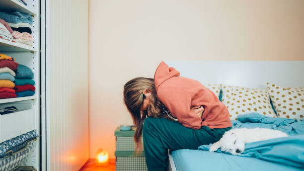 Woman with stomach pain staying home Young woman with painful menstruation resting in bed Endometriosis stock pictures, royalty-free photos & images