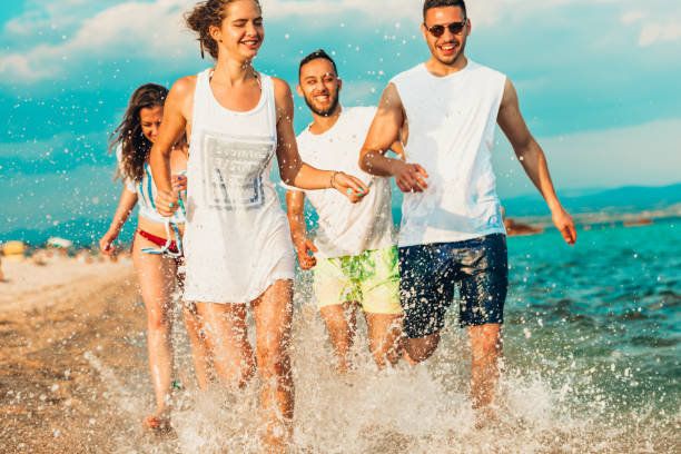 istock Group of cheerful people having beach party and dancing 1385101449