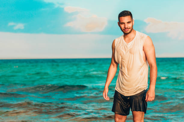 istock Healthy young man with a turquoise sea as a background 1385103832