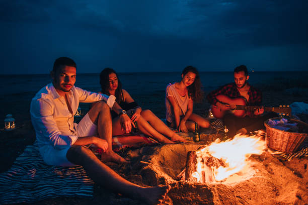 istock Campfire people roasting sausages and playing guitar 1385103866