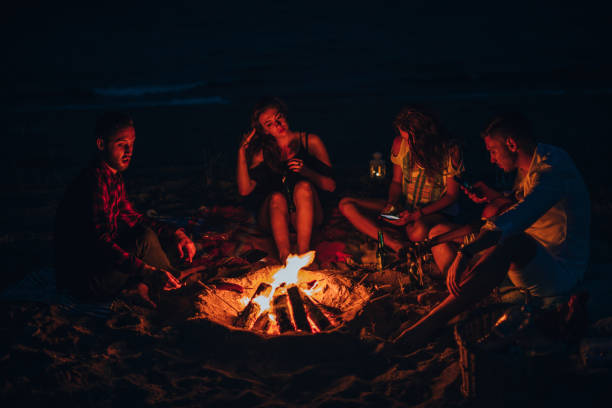 istock Happy friends having fun around bonfire 1385103871