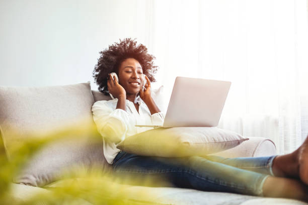 istock Young woman enjoying at home using laptop. 1385104625