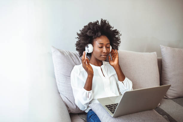istock Young woman enjoying at home using laptop. 1385104627