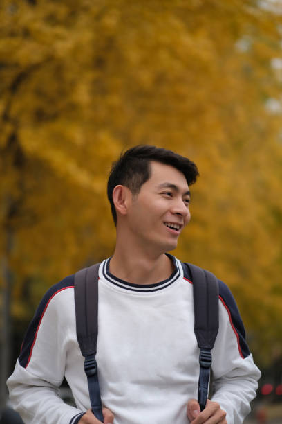 istock Asian male college student carrying backpack  and smiling side face 1385108271