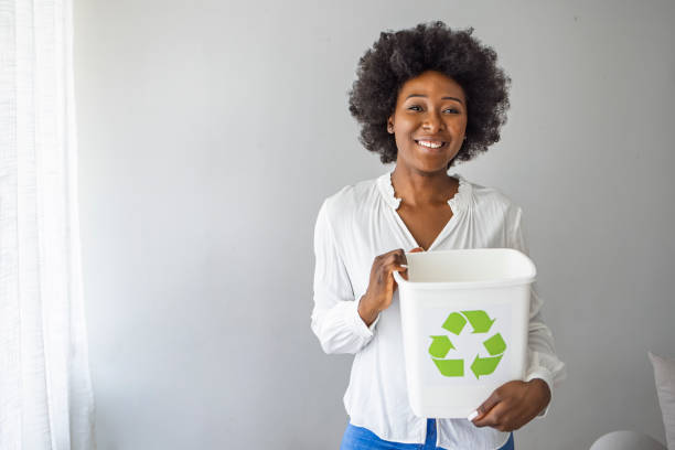 istock Woman carrying recycle bin. 1385108330