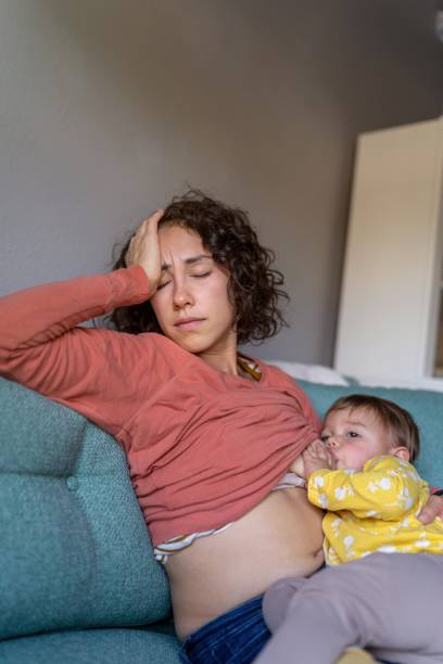 istock Exhausted mom breastfeeding toddler daughter 1385109622
