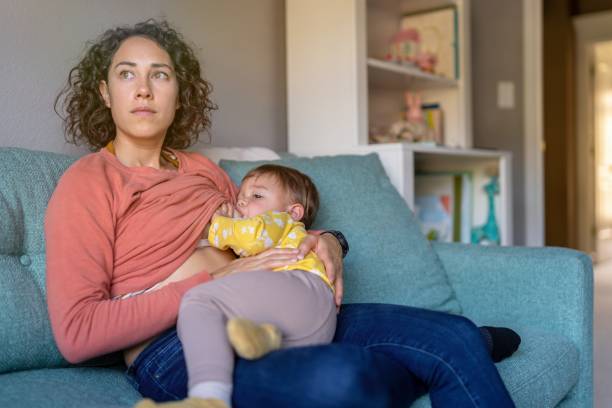 istock Young mom breastfeeding toddler daughter before her nap 1385109624