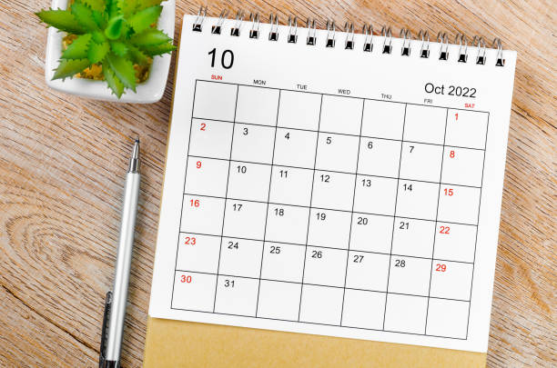 October 2022 desk calendar with pen on wooden table. The October 2022 desk calendar with pen on wooden table. number 10 photos stock pictures, royalty-free photos & images