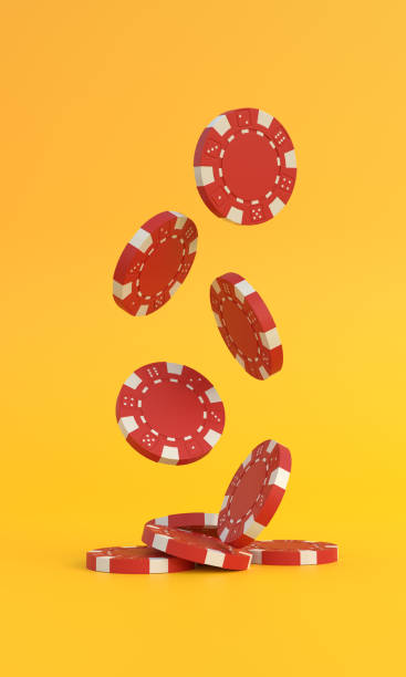 istock Lots of red poker chips falling down on a yellow background with copy space 1385111724