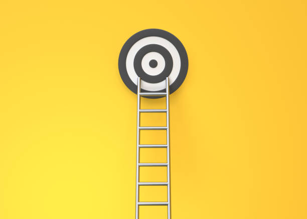 Step ladder and target on a yellow wall with copy space