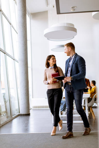 istock Young entrepreneur couple walking together and using digital tablet in the modern office 1385114314