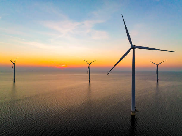 istock Wind turbines in an offshore wind park producing electricity during sunset. 1385114428