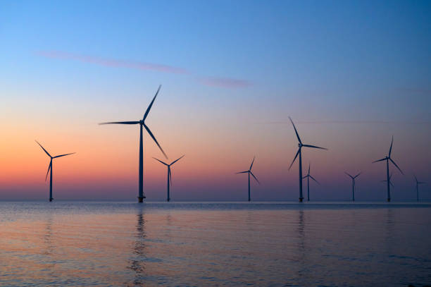 istock Wind turbines in an offshore wind park producing electricity during sunset. 1385114678