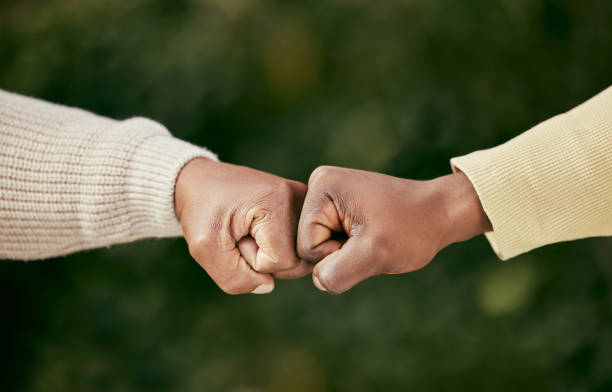 istock Shot of two unrecognizable men bumping fists outside 1385117320