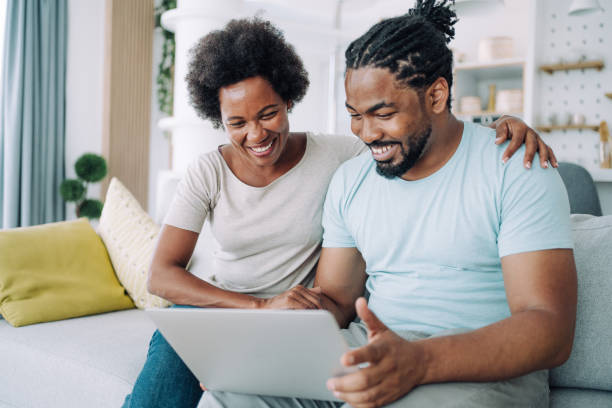 istock Couple using laptop on the sofa at home. 1385117873