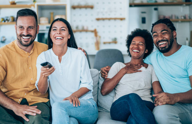 istock Cheerful friends watching TV at home. 1385117877