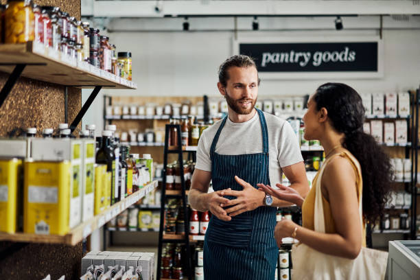 istock Shot of a young man helping a customer while she shops in his organic store 1385118955