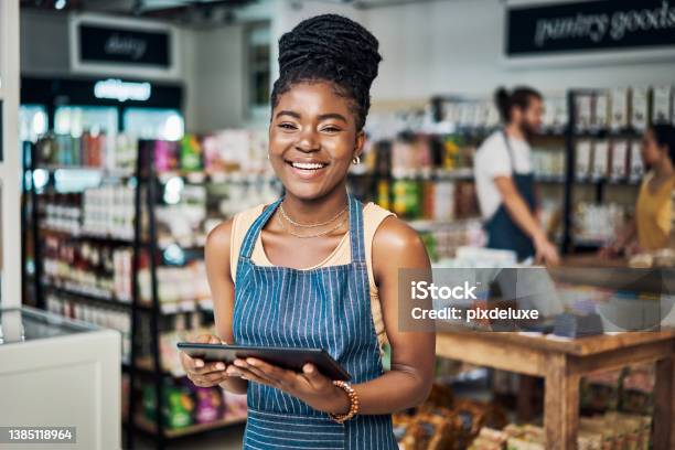 Shot Of A Young Woman Using A Digital Tablet While Working In An Organic Store Stock Photo - Download Image Now