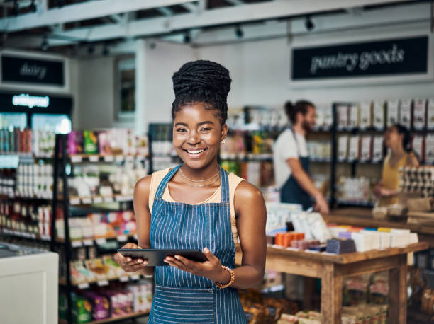 istock Shot of a young woman using a digital tablet while working in an organic store 1385118968