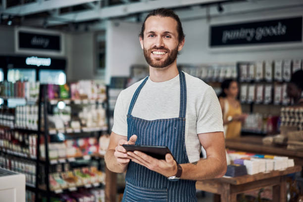 istock Shot of a young man using a digital tablet while working in an organic store 1385118974