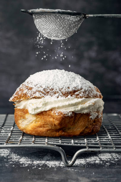 Traditional Scandinavian Semla Cream Cake. Fastelavnsbolle or Fastelavn Cakes are a Danish delicacy made and eaten in great quantities in the period up to the beginning of Lent in many parts of Scandinavia. Made from puff pastry and filled with cream and or jam and topped with a variety of different flavours, fruits, chocolate and icing or just a simple dusting of sugar. Colour, vertical format with copy space. cream cake stock pictures, royalty-free photos & images